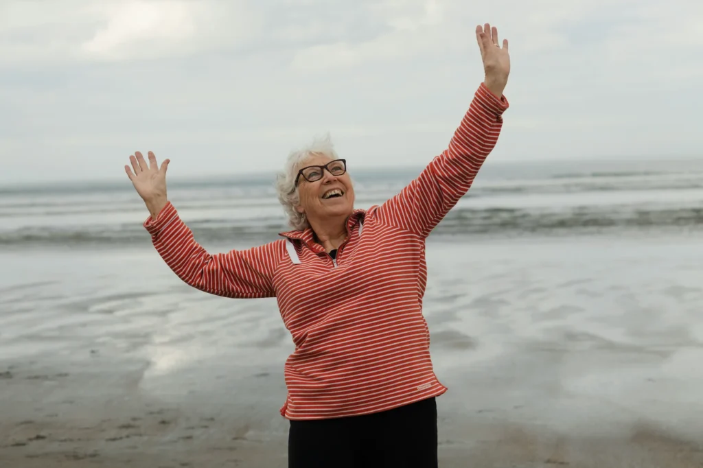Persona mayor mostrando felicidad y superación gracias a un estilo de vida activo.
